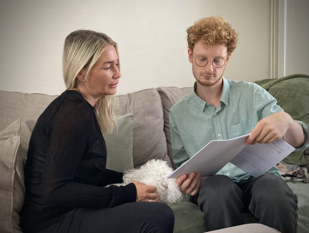 Housing advice drop-in, Two people sat on sofa reading text